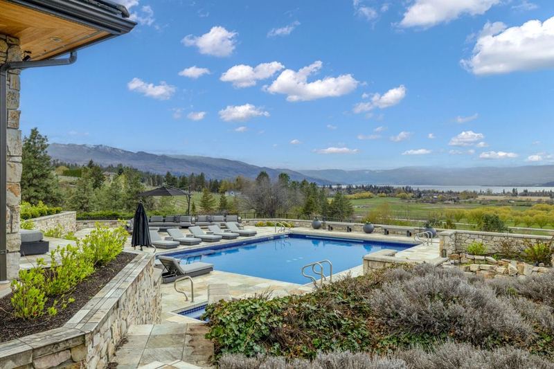 Backyard pool and lake view at a Kelowna listing, photographed by Tour Shots