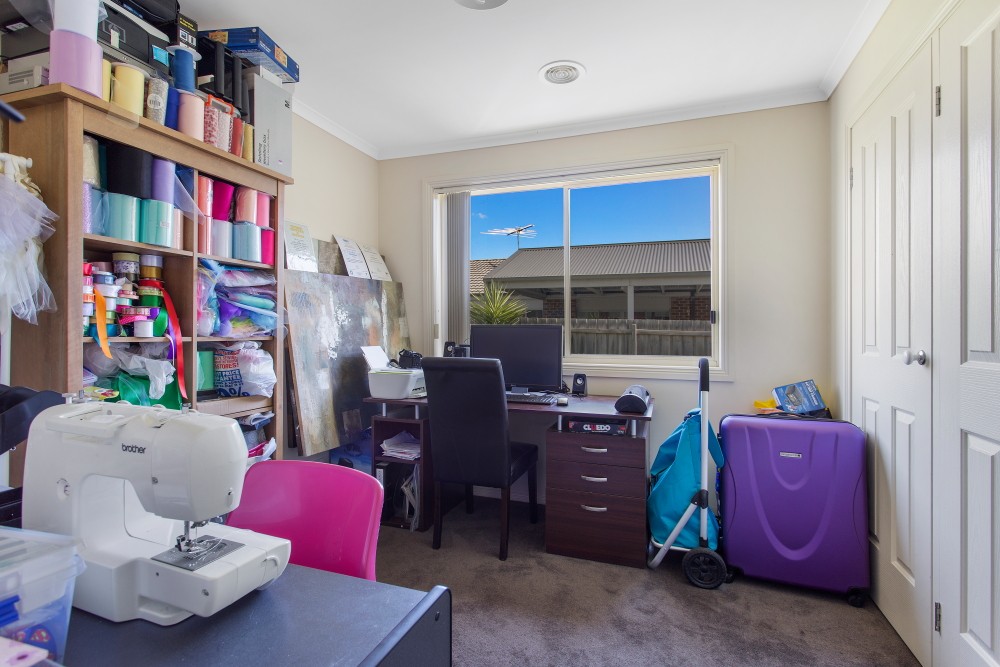 Spare room full of craft supplies, boxes and furniture