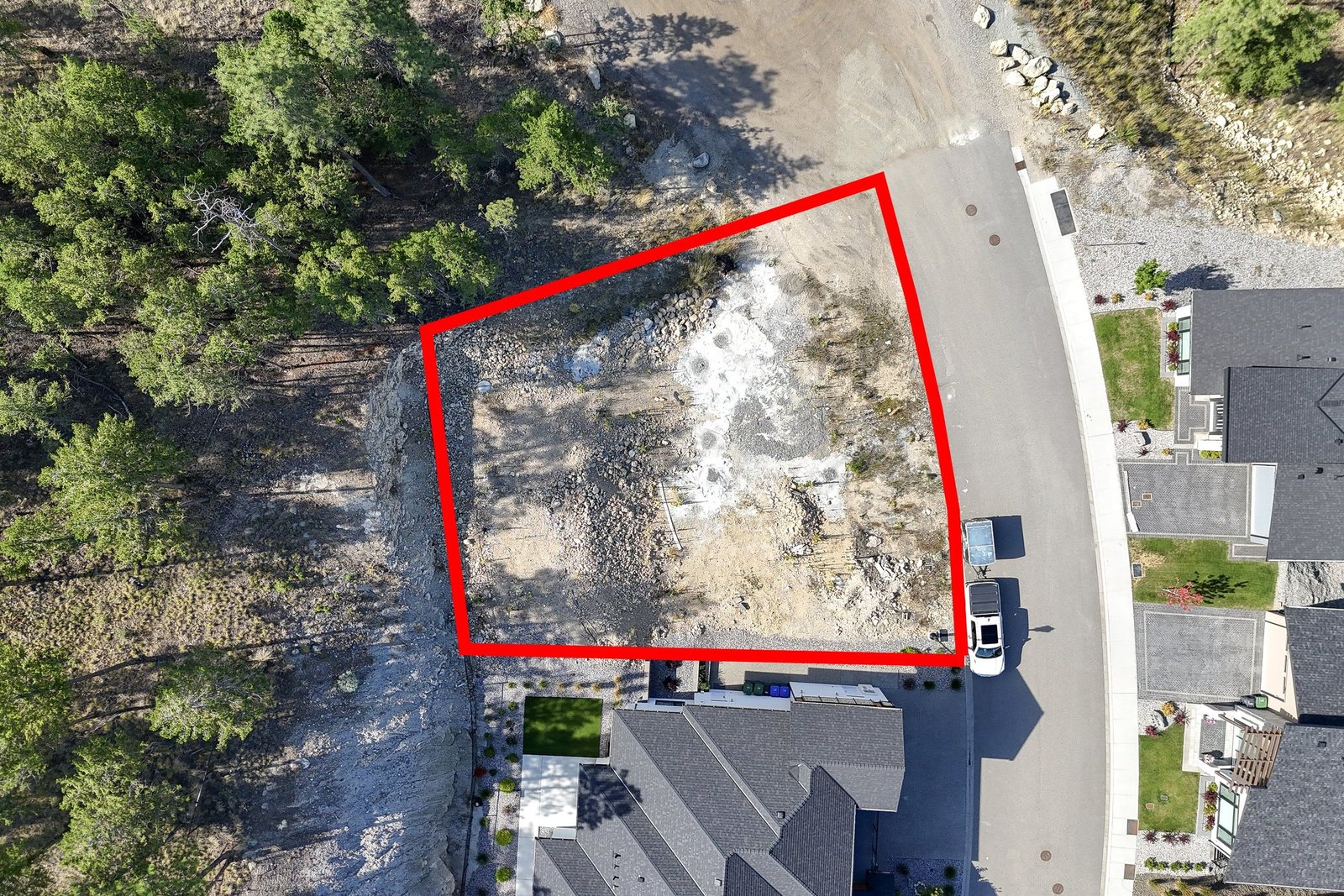 Aerial photo of a vacant lot with the approximate property lines drawn in red